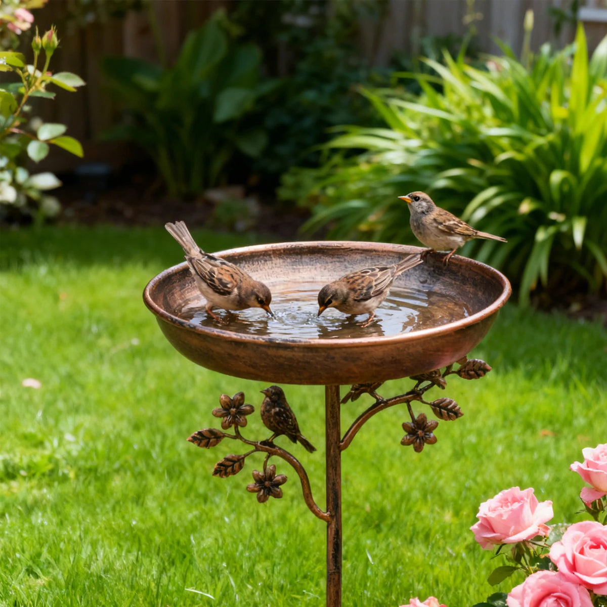 Robuste Outdoor-Gießkanne aus Eisen mit Wasser, eine Vogel trinkt aus der Schale im grünen Garten.