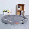 A gray luxurious corduroy pet sofa bed for dogs and cats resting on a light gray surface.