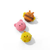Three plush toys: an orange and brown striped hedgehog, a pink round ball, and a yellow chick.
