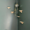A decorative storage rack with mushroom-shaped pieces is mounted on a green wall.
