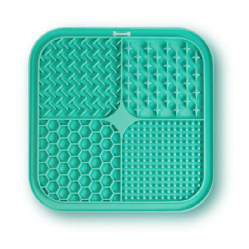 A teal silicone pet licking mat with suction cups divided into four sections for slow feeding