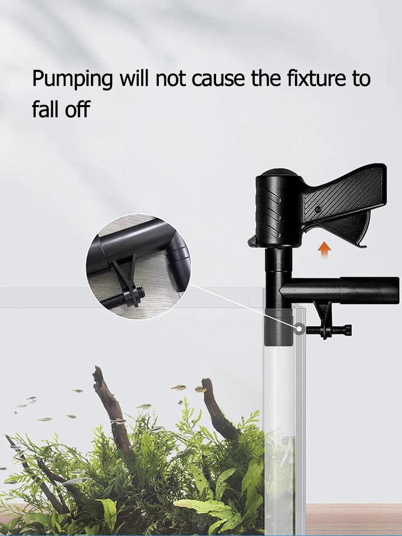 A black manual aquarium water change pump is shown next to a glass tube, with surrounding aquatic plants.