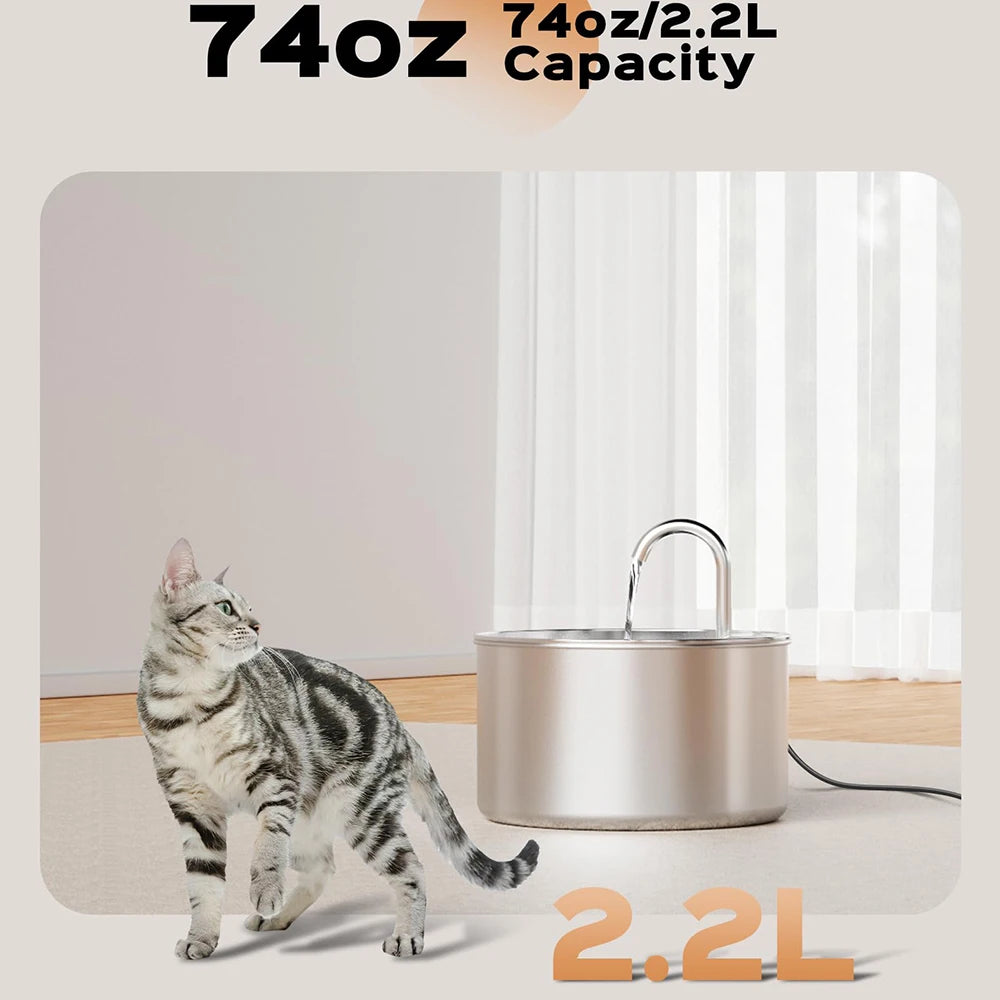 A stainless steel pet water fountain with a lid is shown on a light surface next to a cat.