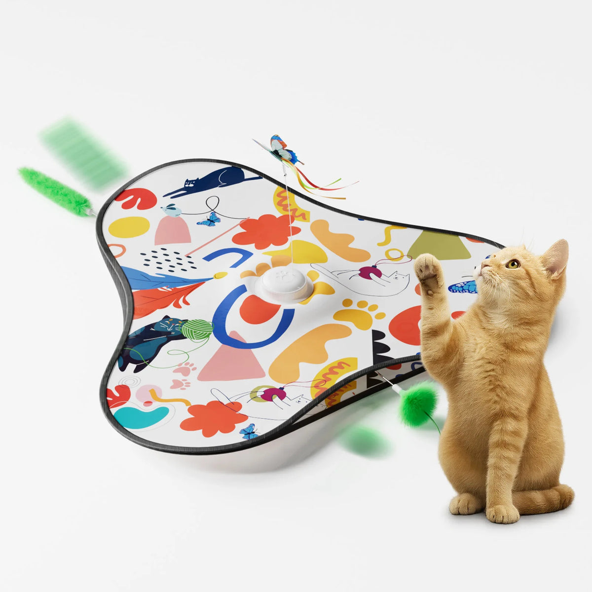 A fluffy orange cat is interacting with an interactive hide and seek toy featuring colorful patterns and motion-activated fea