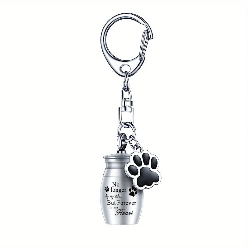 Stainless steel memorial pet ashes keychain with a paw print charm.