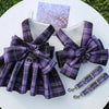 A purple and black plaid reusable dog harness dress with a mesh lining displayed on a white surface.