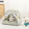 Un chat gris et duveteux se détend dans un lit de tente pour animaux vert clair, décoré de tissu blanc transparent et d'accen