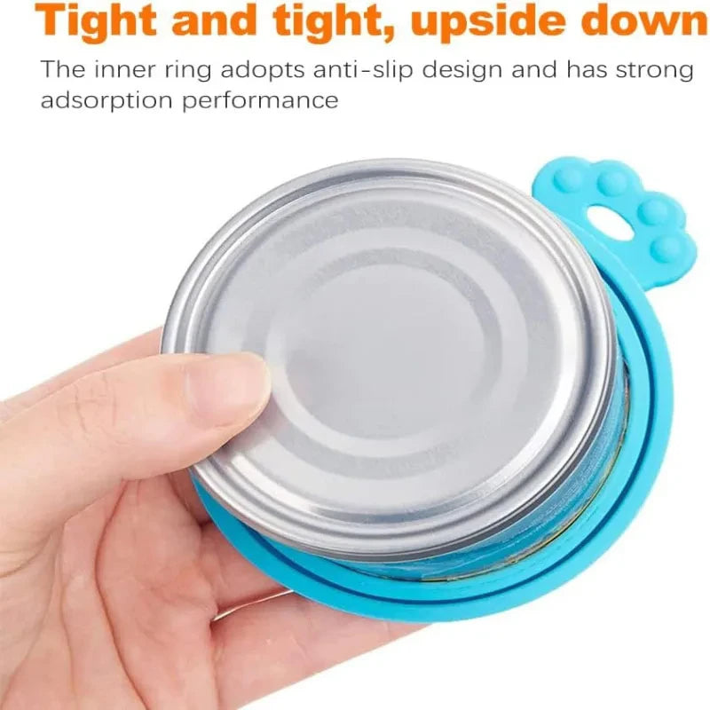 A hand holds a reusable silicone pet food can lid with a spoon, showing the anti-slip design.