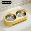 A yellow-colored elevated feeder stand with two stainless steel bowls for dogs or cats.