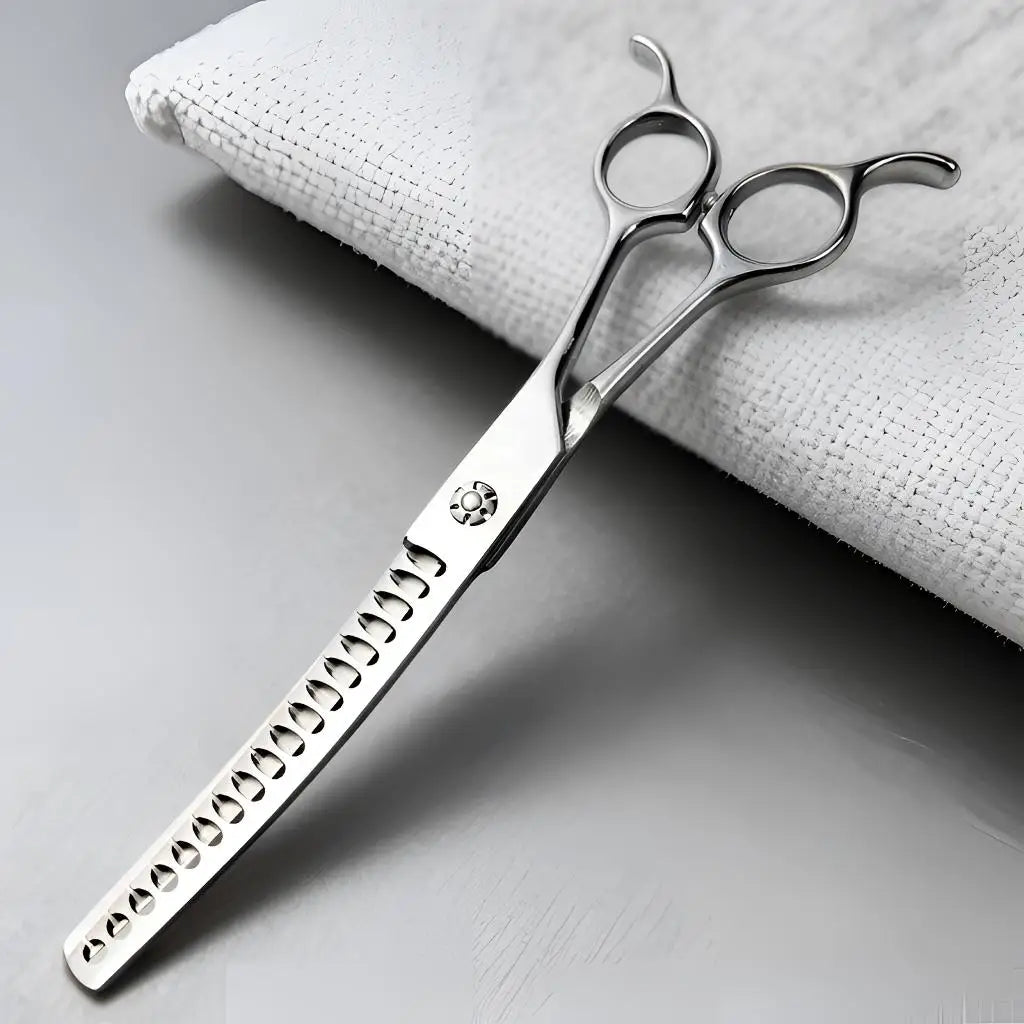 Silver professional pet grooming scissors with a textured handle resting on a white cloth.