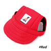 A bright red visor cap with a black patch featuring an orange dog silhouette for pet grooming and fashion.