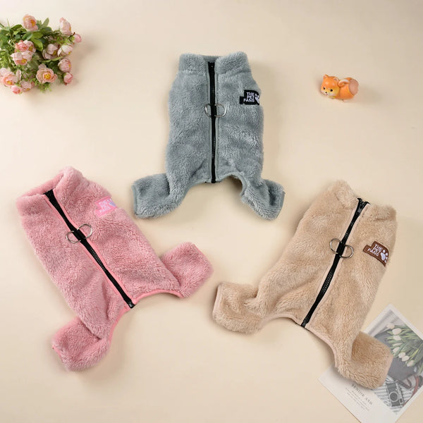Three cozy fleece dog jumpsuits in pink, gray, and beige are displayed on a light background.