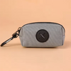 A gray zippered pouch with a black circular cross design and a metal clip.