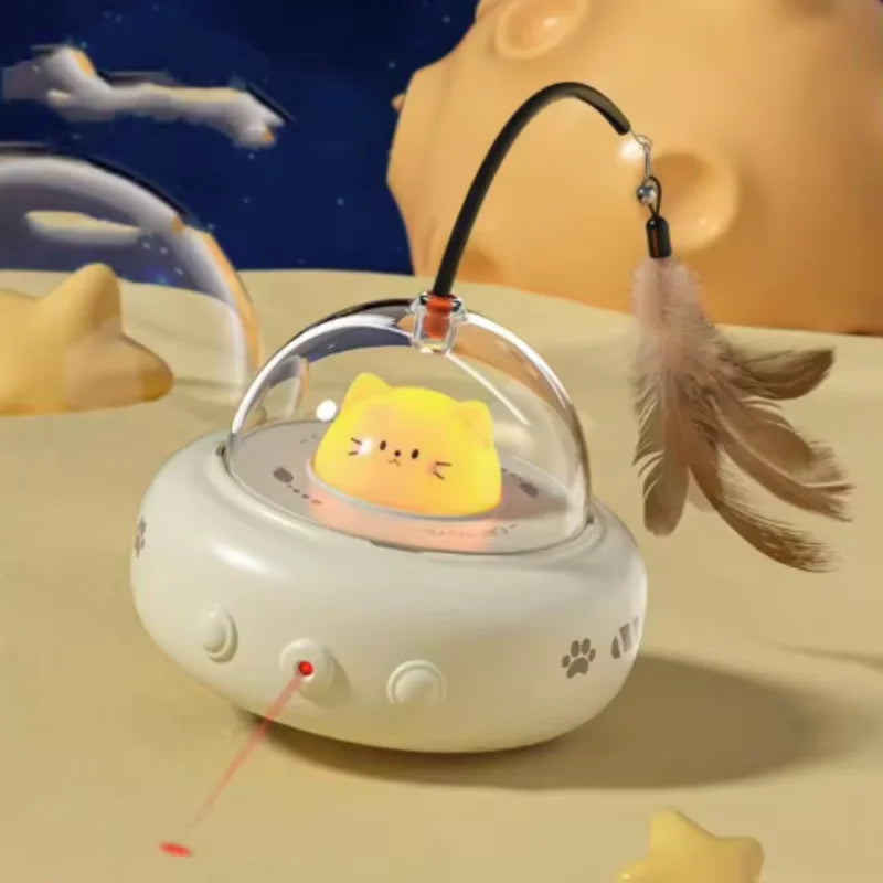 A white electronic cat toy with a rotating feather attached, resting on a light yellow surface.
