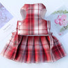 A red and pink plaid reusable dog harness dress with a padded back and gathered skirt.