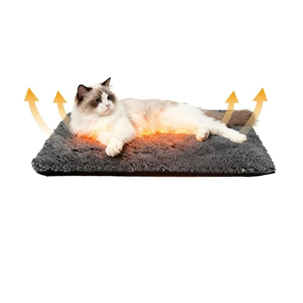A fluffy white and gray cat is lying on a dark gray self-warming pet mat.