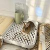 A white universal pet litter box for small animals with a clear water dispenser and natural bedding.