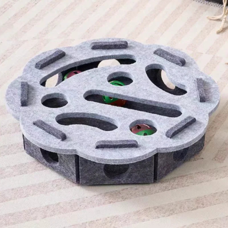 A gray felt maze puzzle toy for cats with a bell ball, featuring multiple holes and tunnels.