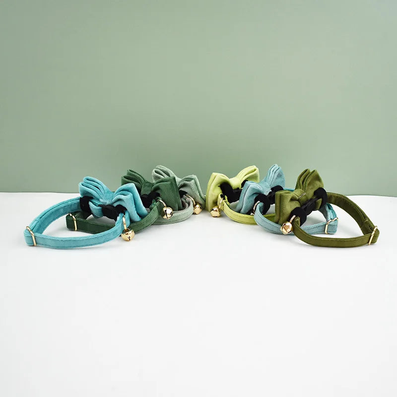 A collection of elegant velvet cat collars in teal, olive green, and sage green with adjustable safety buckles.