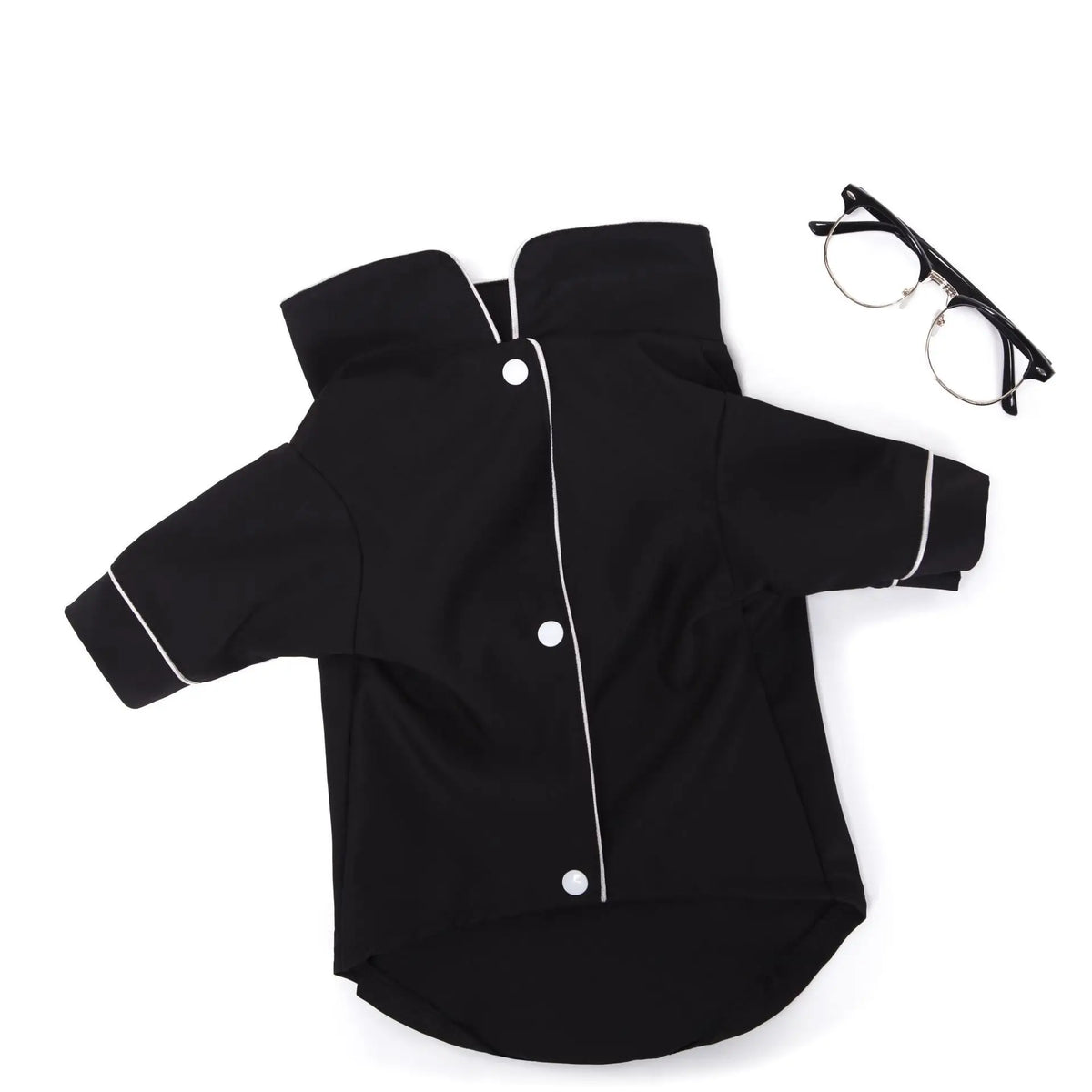 Black luxury silk pet pajamas for dogs lying flat with eyeglasses nearby