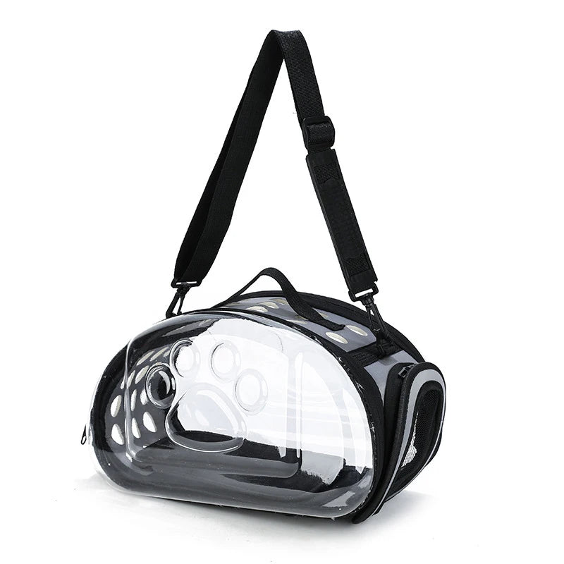 A clear, foldable pet travel carrier with a black shoulder strap is shown against a white background.