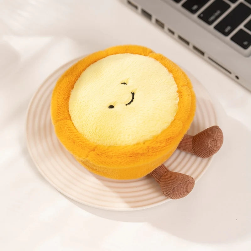 A round, yellow plush toy resembling a sun with a smiling face, resting on a light pink plate.