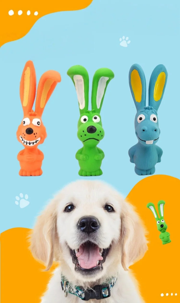 A golden retriever dog smiling while holding a natural rubber squeaky rabbit chew toy.