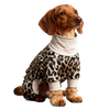 A brown dog wearing a leopard print jumpsuit and a white collar, looking to the right.