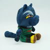 A dark blue cartoon goat plush toy with gray markings and a green shirt.
