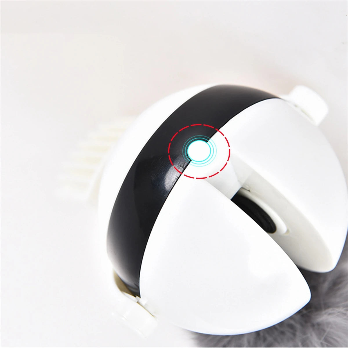 Jouet interactif de chat blanc avec balle noire rotative et voyant lumineux.