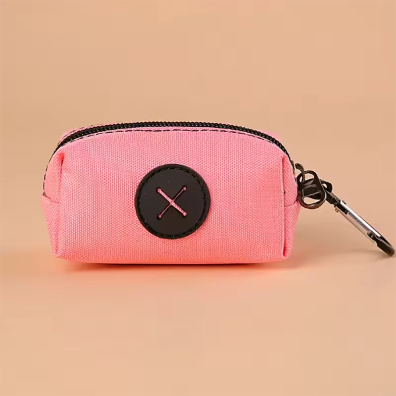 Pink fabric pouch with a black circular cross design and attached to a metal carabiner clip
