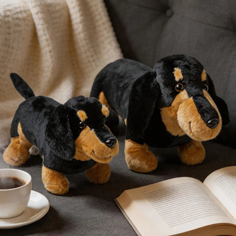 A black and tan dachshund plush toy lying next to a cup of coffee on a dark surface.
