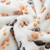 White fleece pet blanket with an orange and gray paw print pattern, rolled up.