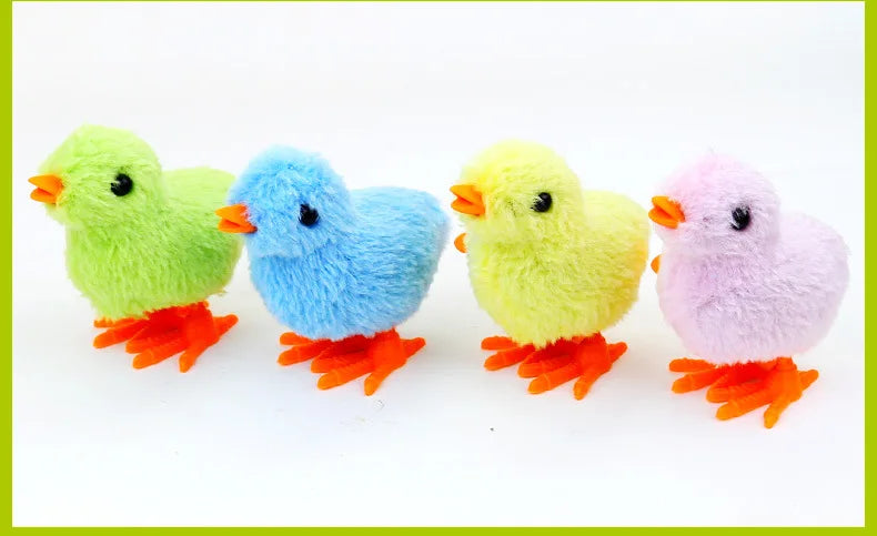A row of four wind-up plush chick cat toys in green, blue, yellow, and pink.