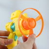 A hand is holding a yellow and orange slot design toy, which is a cat flying disc launcher.