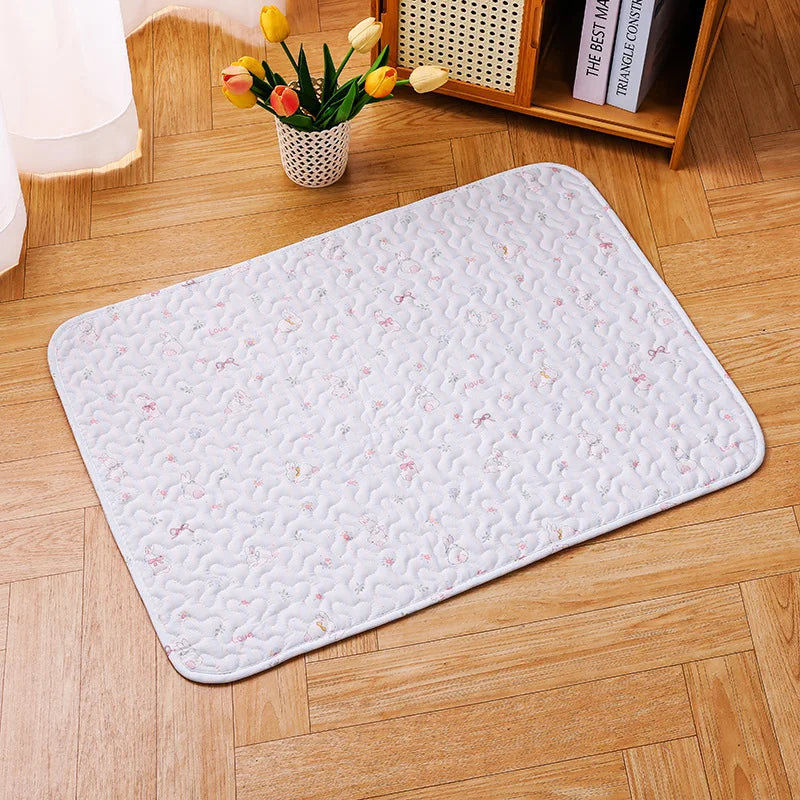 A white soft cotton pet cage mat with a quilted pattern and non-slip base placed on a wooden floor.