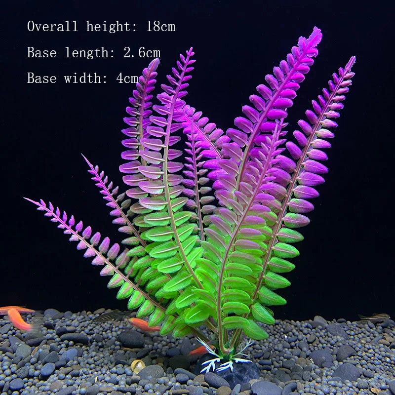 A vibrant artificial aquarium plant with pink and green foliage growing in dark gravel.