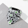 A black and white pet collar with a green paw print bandana featuring dog bone and heart patterns.