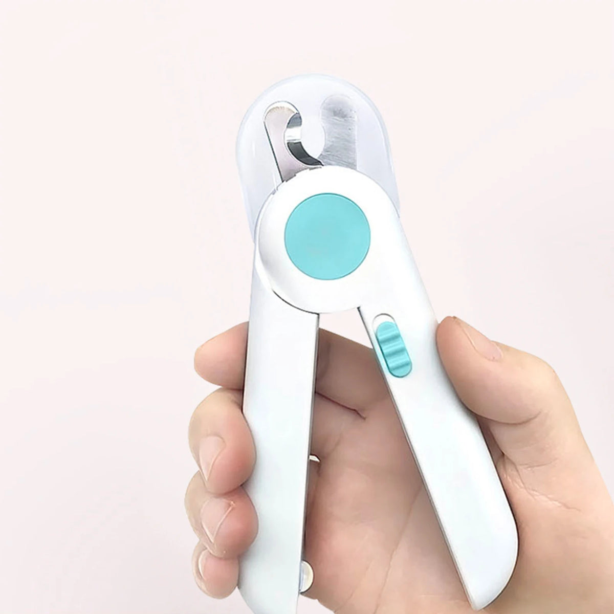 A hand holds a white LED pet nail clipper for cats and dogs with a light blue grip.
