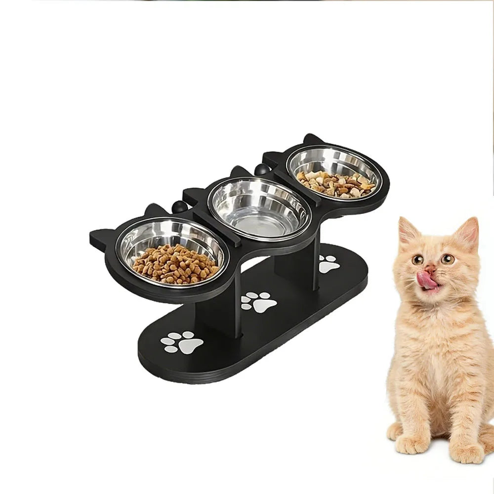 A black elevated cat food bowl stand with three stainless steel bowls filled with dry food.