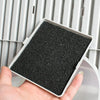 A hand holds a rectangular black filter pad for an activated carbon litter box filter system.