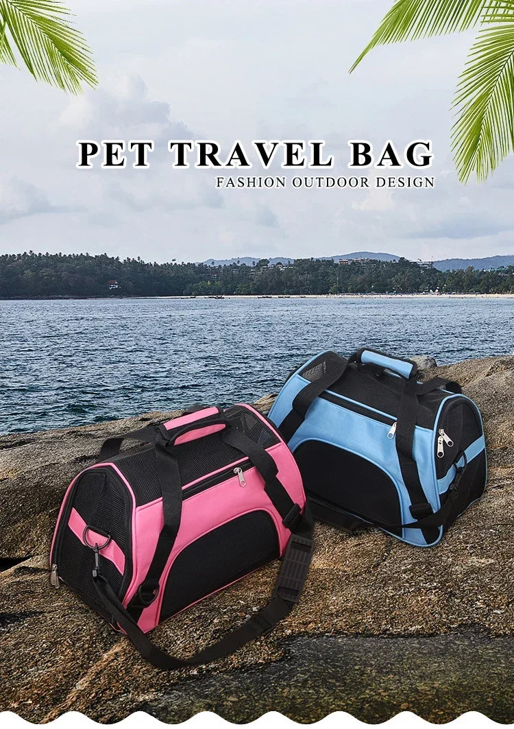 A pink and black pet travel bag is placed on a rock near the ocean with lush greenery in the background.