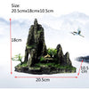 A resin aquarium rockery featuring a jagged cave structure and a small tree on a mossy rock base.
