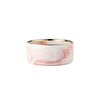 A set of double pet bowls made of marbled pink ceramic with a gold rim and a wooden stand.