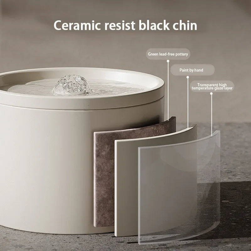 A ceramic resist black chin pet water fountain with a clear glass layer and a dark mat.