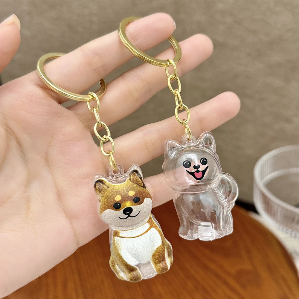 A gold-colored keychain featuring a puppy-shaped pet hair keepsake with a white and brown fur texture.