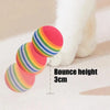 Three rainbow colored EVA rattle balls shown next to a white cat paw, demonstrating a bounce height of 3cm.
