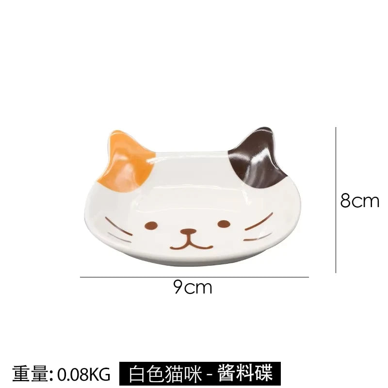 White ceramic cat-shaped sauce dish with brown accents, measuring 9cm by 8cm.