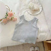 A light blue knitted mini vest with lace trim and a small embroidery detail displayed on a white surface.