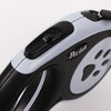 Close-up view of a black and silver retractable nylon dog leash with a handle and a paw print design.
